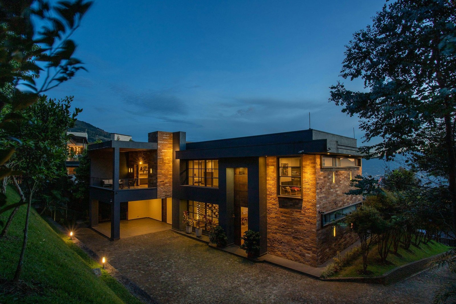 Contemporary luxury villa with warm lighting at dusk