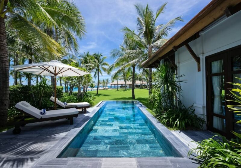 Private lap pool with sun loungers surrounded by greenery