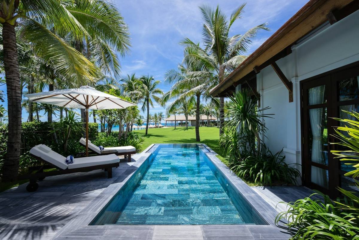 Private lap pool with sun loungers surrounded by greenery