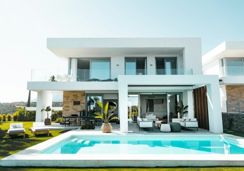White contemporary villa with pool deck and outdoor lounge